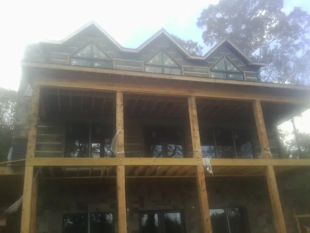 Dormers and porch framing on a large log home under construction — Roof Coating work by our crew in Philomath