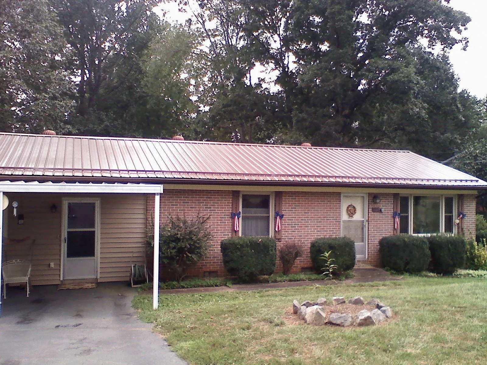Bronze metal roof and carport on a brick ranch home — Roof Repair work by our crew in Philomath